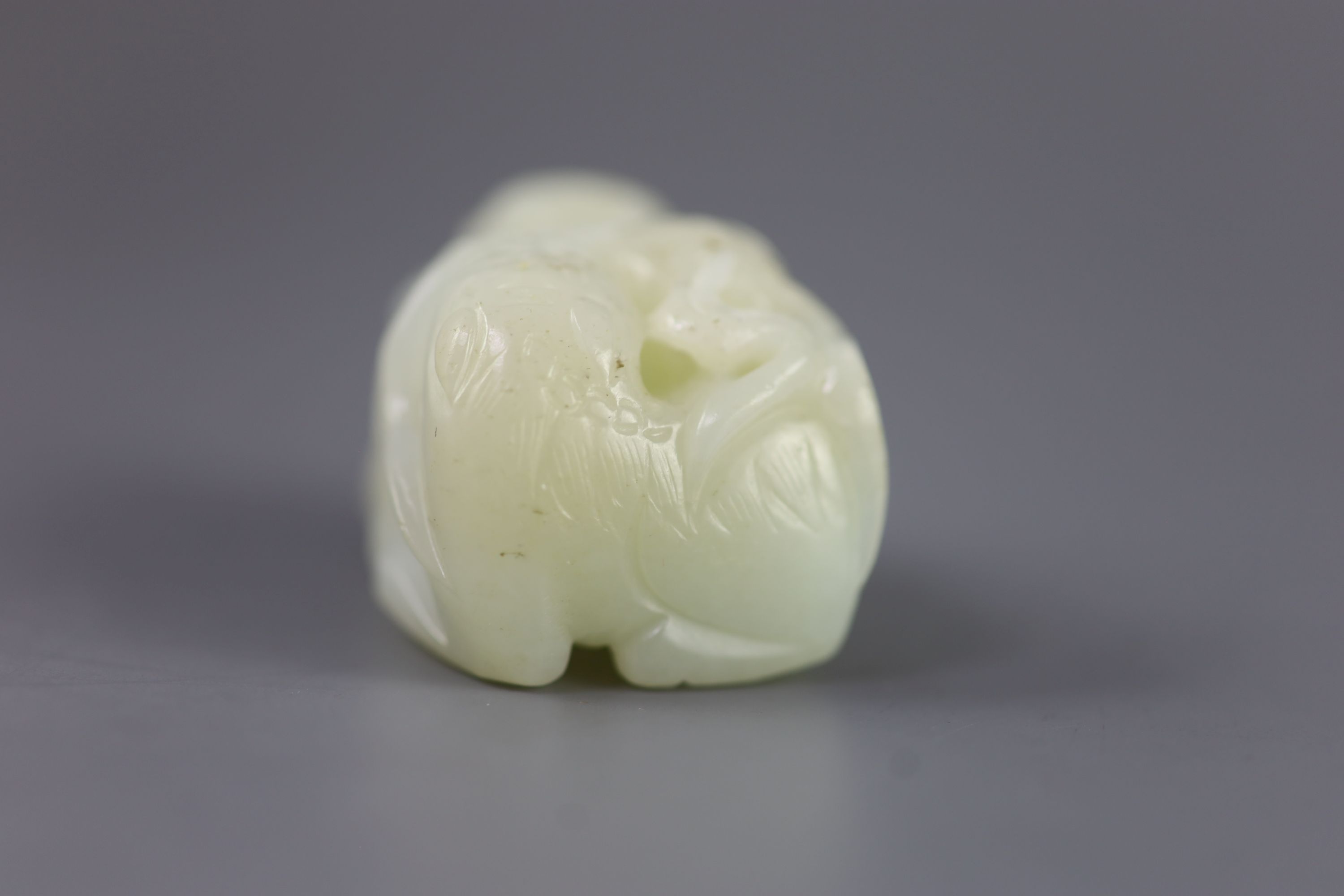 A Chinese pale celadon jade group of a boy and a lion-dog, 19th/20th century, 5.4cm